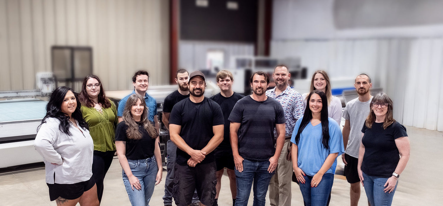 Group of people posing for a photo in an industrial setting