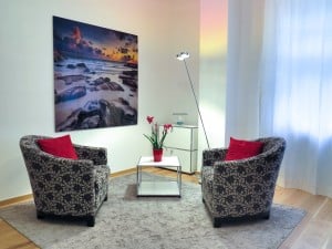 living room with large painting of rocky beach at sunset